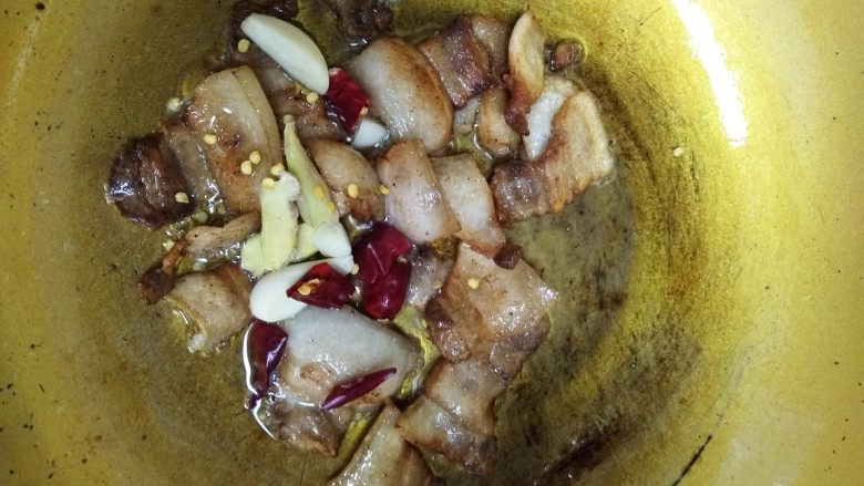 回锅肉,炒出油脂后锅内留少许底油,放入姜,蒜,干辣椒炒香