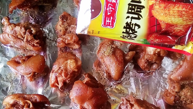 快手正餐烤猪手,将猪手控干水分,放入事先铺好锡纸的烤盘,撒入孜然,烧烤料