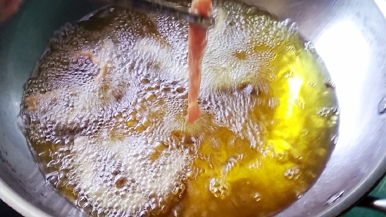 五香炸肉,锅中热油,放入元宝肉,炸至肉熟即可(一会还要复炸)
