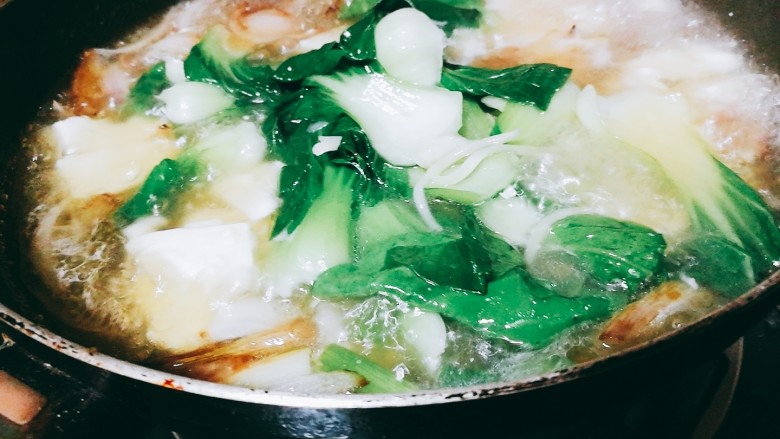快手菜,腊肉番茄豆腐汤,在炒锅中加水,加入豆腐,大火烧开,加入焯过水的菜胆