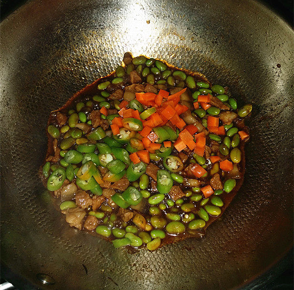 杭椒毛豆米小炒肉,炖至3~4分钟后下入杭椒、胡萝卜,再加些咸盐,开大火翻炒均匀