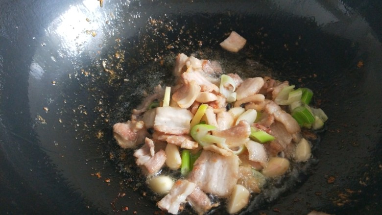 快手正餐 五花肉炒蒜苔,锅中放入适量油烧热,倒入五花肉炒上色,放入葱姜,酱油,<a style='color:red;display:inline-block;' href='/shicai/ 718'>料酒</a>炒均匀。