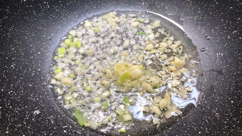 剁椒蒸鸡翅,热锅放入适量油,放入葱白和蒜末爆香