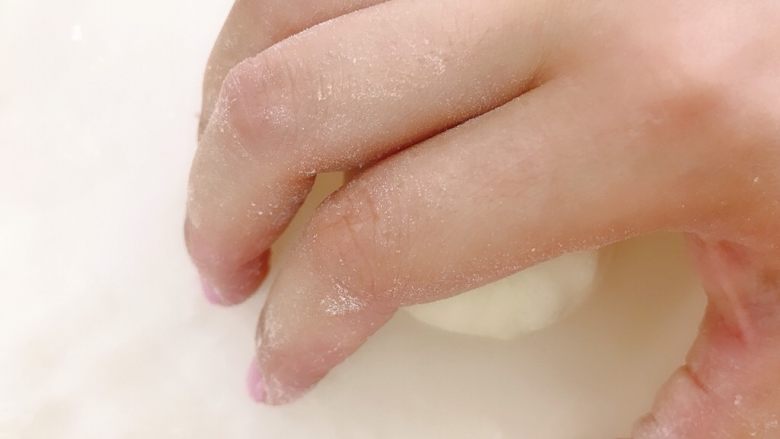 柠檬乳酪软欧包,分割成50g一个小面团,用手收圆,手指接触操作台,面团光滑面朝上,可以少量沾点粉防粘,与操作台接触的一面不沾粉,手画圈转动,用手掌的力将面团揉圆收紧