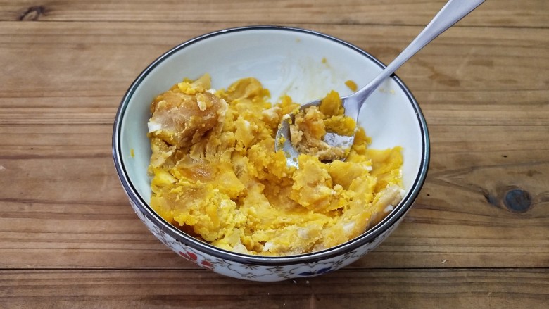 蛋黄焗南瓜,趁着腌制的时间里,我们把咸蛋黄用勺子压成泥。