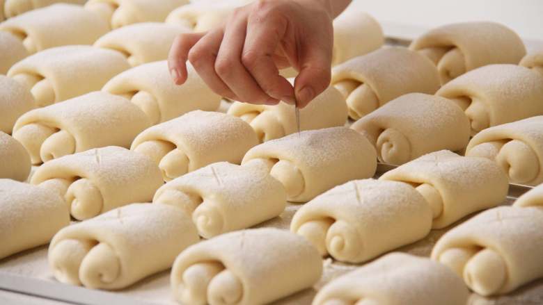 胖墩牛奶面包,发酵好的面团在表面筛一层薄薄的面粉，用利刀在中间位置割浅的”X ”切口。