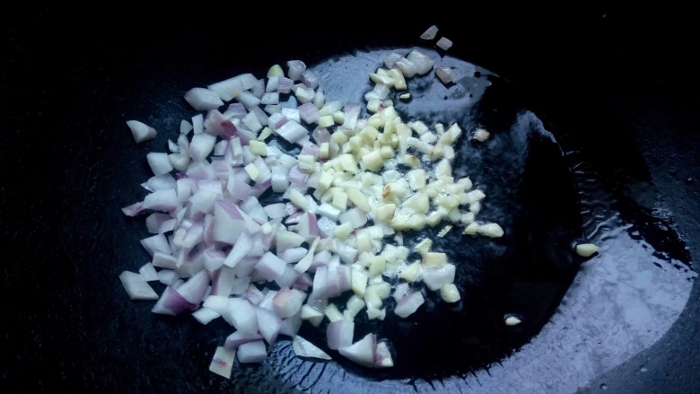 穿肠意面,锅中加入食用油或黄油,烧热后倒入洋葱丁和大蒜丁爆香。