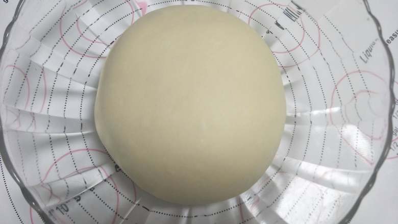 烘焙入门级基础小餐包,滚圆面团,收口向下,覆盖保鲜膜放置到温暖的地方发酵。