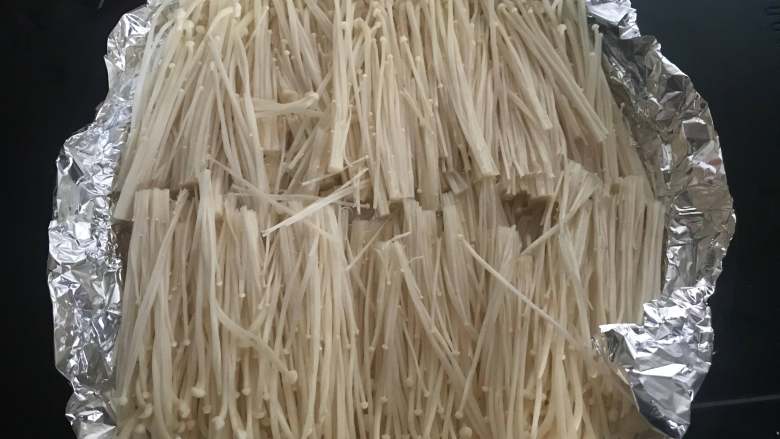 夏日必点~烧烤金针菇,掰开金针菇洗干净,捏干水分摆盘放锡纸上。