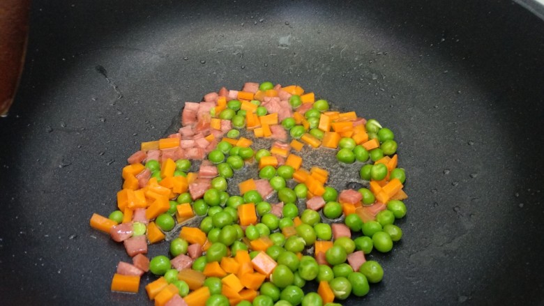 菠萝炒饭,倒入豌豆和胡萝卜翻炒均匀。