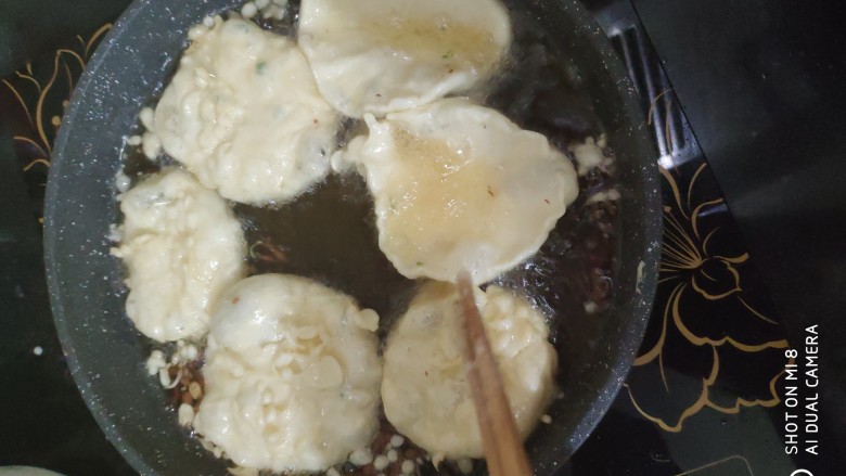 快手小食 油炸果子,用勺子把面糊一勺一勺的舀进锅里,用筷子多翻几个面,保证受热均匀