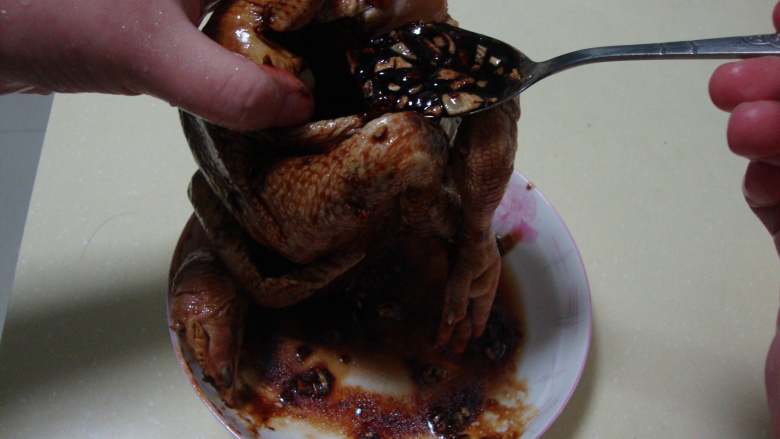 吉祥如意:金牌蒜香鸡,调好的酱料抹到鸡的身上,剩下的全部灌入鸡腹中,把鸡的爪子塞入肚子中