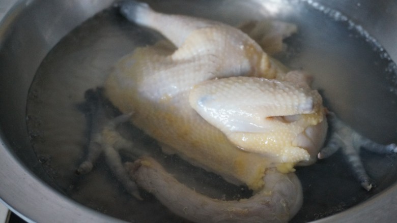 夏日凉菜白斩鸡,倒入<a style='color:red;display:inline-block;' href='/shicai/ 718'>料酒</a>,把鸡放进去焯下水,煮开后翻面在焯一下