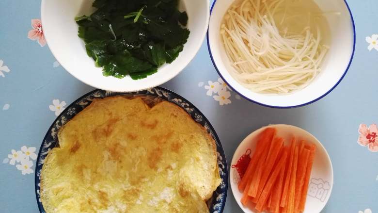 豆腐卷,原料集合啦,煎好的蛋皮,胡萝卜切条状,焯好的金针菇和芹菜叶。