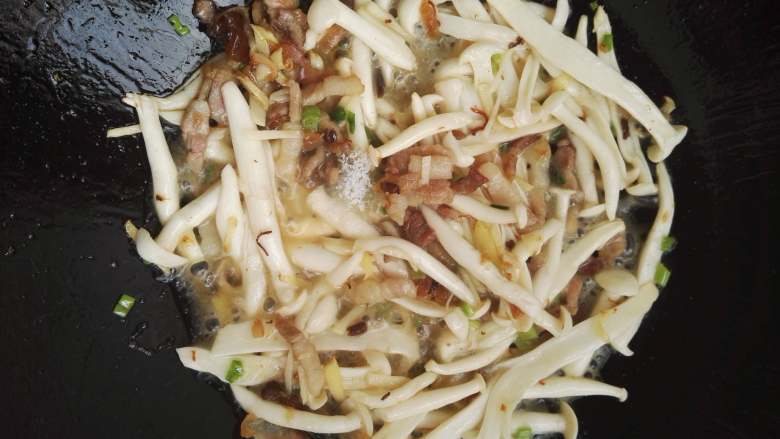 白玉菇荷兰豆炒五花肉,可以加入少许的清水烧一下,加入盐,翻炒均匀。