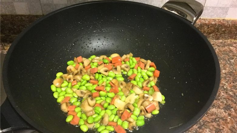 青豆炒蘑菇,放入青豆和火腿肠翻炒1分钟。