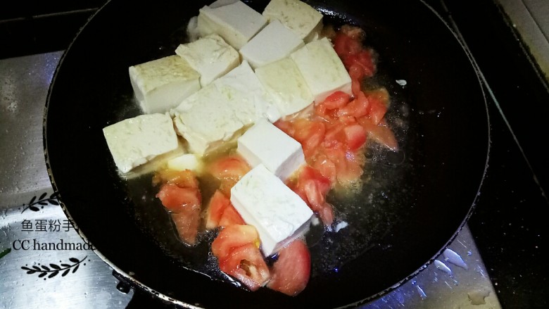 甜酸豆腐,加入番茄块到锅里,用铲子轻轻的来回推动豆腐和番茄,番茄开始出水后用过盖子盖上闷煮约三分钟。