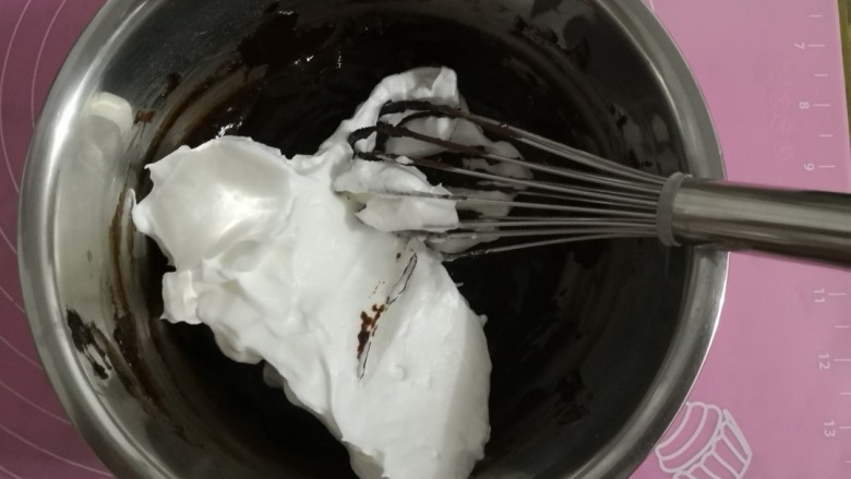 巧克力戚风蛋糕,先取三分之一的蛋白倒入蛋黄糊中翻拌均匀,切不可画圈搅拌,否则消泡。这时候预热烤箱150度15分钟。