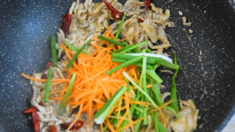 快手辣炒肉丝超下饭,米饭都多吃一碗,放入辣椒丝、胡萝卜丝、葱段,炒至断生即可。