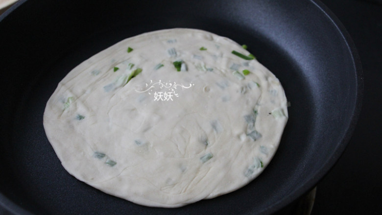 葱香千层手抓饼,擀成薄薄的圆形,平底锅倒少许油,放入饼胚两面煎黄。