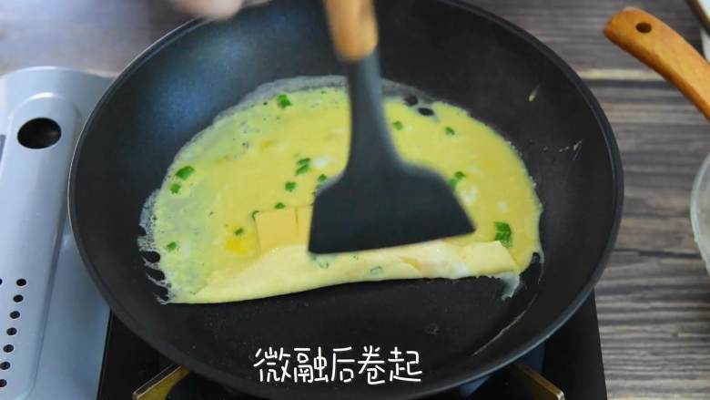 葱香芝士蛋卷—色彩丰富口感更丰富,铺一层蛋液,半凝固后,放入芝士片。
微融后卷起。