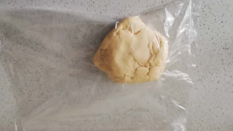 糖霜饼干之平整饼干底,将面团放入保鲜袋中,用擀面杖擀成3-4毫米的薄片。