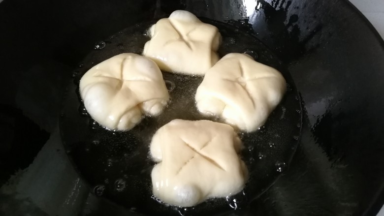 椰蓉炸面包,锅中倒入适量油,烧至五成热后开小火,放入面包卷开始小火炸制。