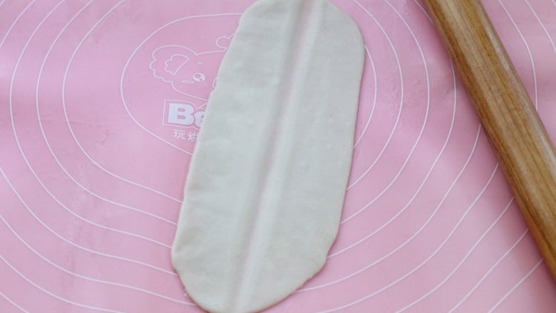 油泼扯面,取一个饧好的面团擀成长舌状,用擀面杖在中间压一下