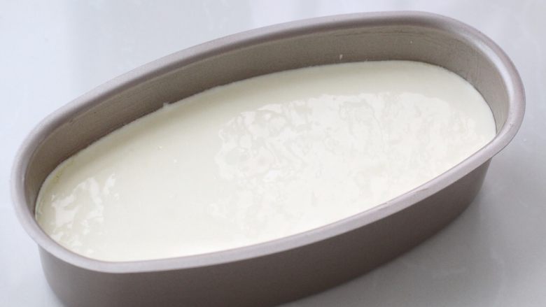 酸奶蛋糕,烤箱上下火135度预热,在轻乳酪模具的底部和内壁涂抹上一层黄油,这样会方便脱模,再将面糊倒入模具中,轻震几下震出大气泡