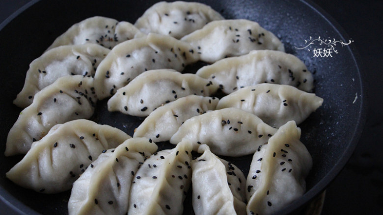 生煎牛肉饺子,煮到水分略干,饺子皮还是潮湿的时候,撒上一层熟的<a style='color:red;display:inline-block;' href='/shicai/ 668'>黑芝麻</a>,盖上盖子小火再焖一两分钟。