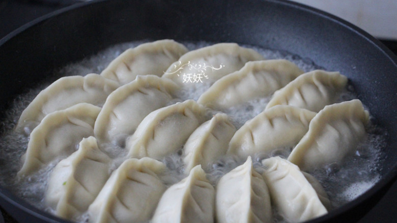 生煎牛肉饺子,到了这个程度就往锅里倒水,水量到饺子的一半就好,继续中小火,盖上锅盖煮大约5到8分钟。