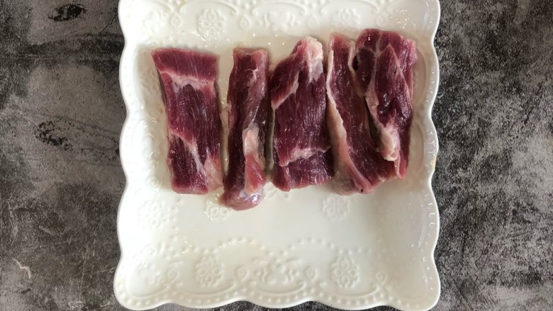 孜然猪肉串,把切好的猪肉穿成串,研磨胡椒和盐腌制,把腌制好的肉串裹上保鲜膜或者保鲜袋,避免风干,放入冰箱冷藏腌制1小时。
