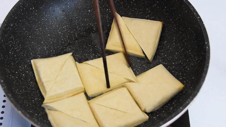 豆制品爱好者不可错过的一道美食,热锅冷油，放入豆干，炸至两面金黄。