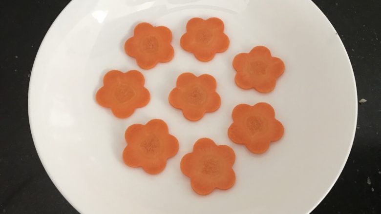 双米蒸丸子,蒸盘上先铺上<a style='color:red;display:inline-block;' href='/shicai/ 2559'>红萝卜</a>片,一来预防丸子沾盘来,二来也好看