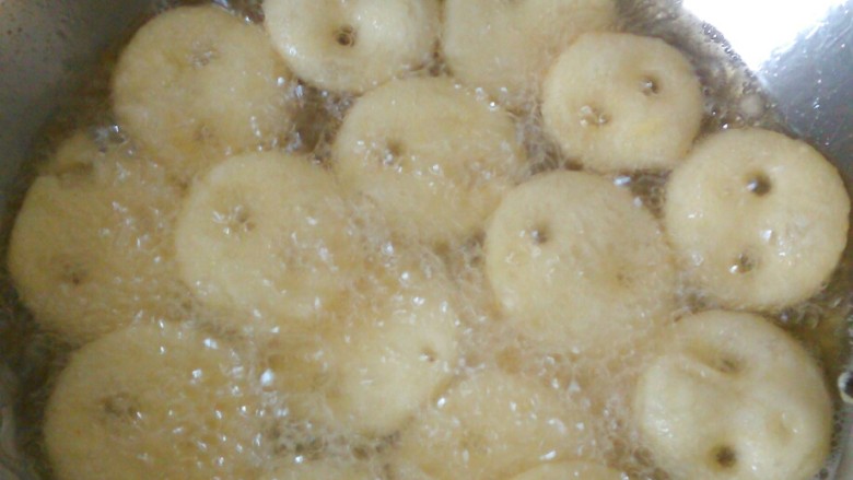 纽扣土豆饼,油温六成热,一个个放入锅内,用小火边炸边翻面,大约炸至六分钟变成金黄色,即可出锅。