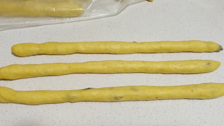 全麦南瓜蔓越莓辫子面包,发好的面团三个一组,分别搓成细长的圆条。