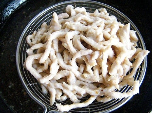 京酱肉丝卷, 起锅热油,3成熟时,下入肉丝炸至如图状态,并捞出控油
