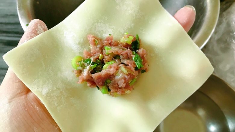 炸饺子,取一张<a style='color:red;display:inline-block;' href='/shicai/ 4346'>饺子皮</a>,放适量的肉馅在中间。边缘抹水。