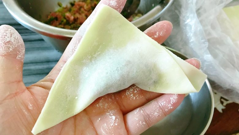 炸饺子,对折成三角形状,周边捏紧。