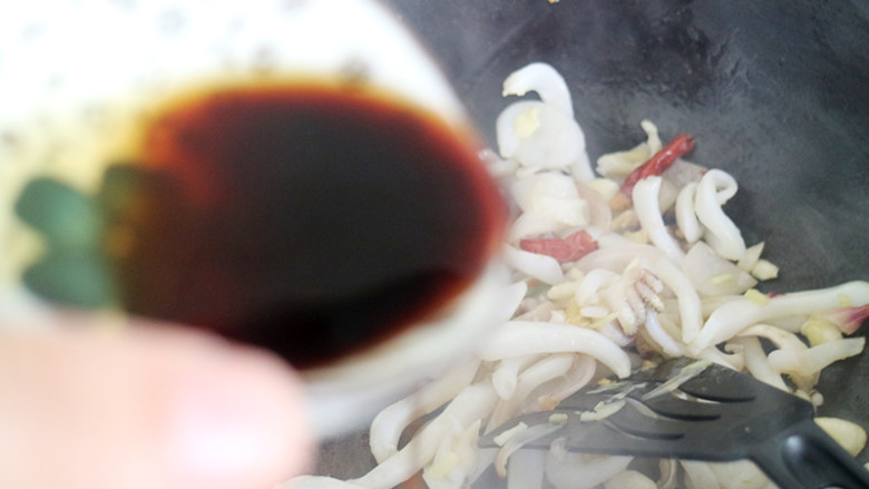 爆炒香辣小鱿鱼,锅中加入酱油、料酒、白糖调味,继续快速炒,料酒是去除海鲜腥味的好伴侣,记得一定要放的。
