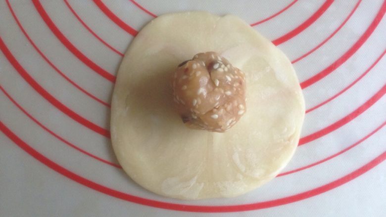 蔓越莓豆沙酥饼,擀成中间厚四周薄的圆形,放入馅料收口。