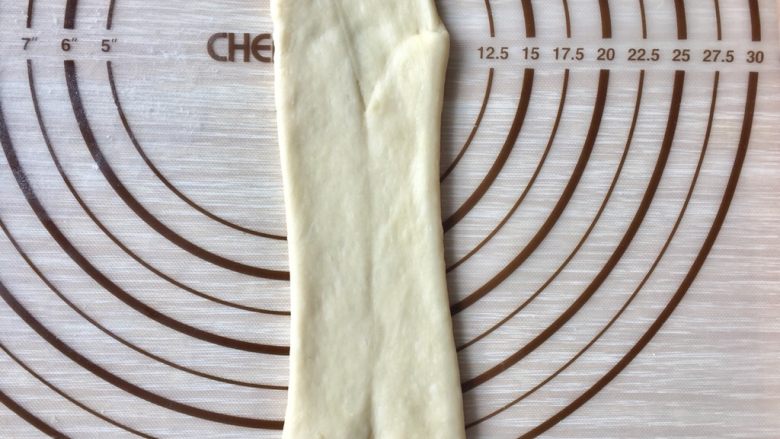 5%冷藏基础发酵牛奶面包,再次擀长后上下同时往中间卷起,翻面过来码入烤盘