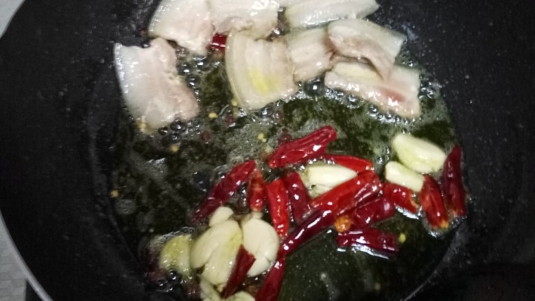 干锅菜花,把肉拨到一边,下蒜和干辣椒,炒香