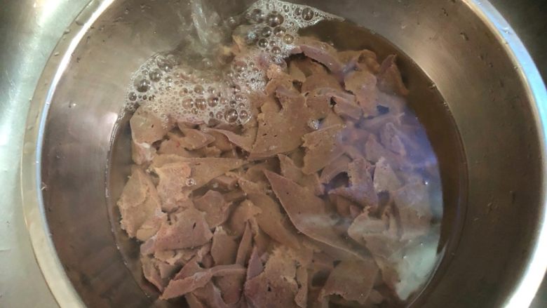 蒜苗炒猪肝,把猪肝放入大碗里,用自来水一直冲洗,冲到水清为止