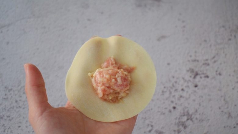 猪肉金针菇饺子,取一张<a style='color:red;display:inline-block;' href='/shicai/ 4346'>饺子皮</a>,中间放入猪肉金针菇