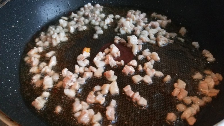 新文美食 椒香孜然炒五丁,锅中在次倒入适量油,倒入肉五花肉丁炒出油。
