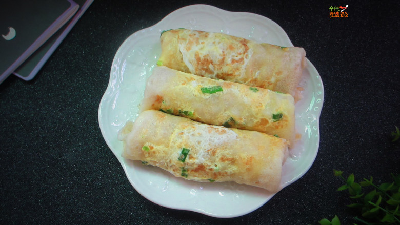 高颜值蛋饼卷,带葱花的一面朝下铺在菜板上,放上炒好的菜,从一侧卷起,封口朝下压住即可