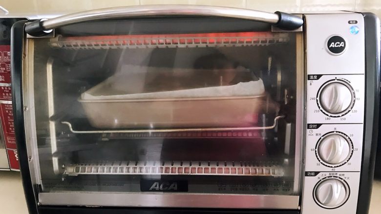 紫薯戚风蛋糕,把烤盘放入预热好的烤箱里,上下火170W,烤70分钟,注意观察蛋糕表面的颜色,如果颜色过深,就盖上一张锡纸