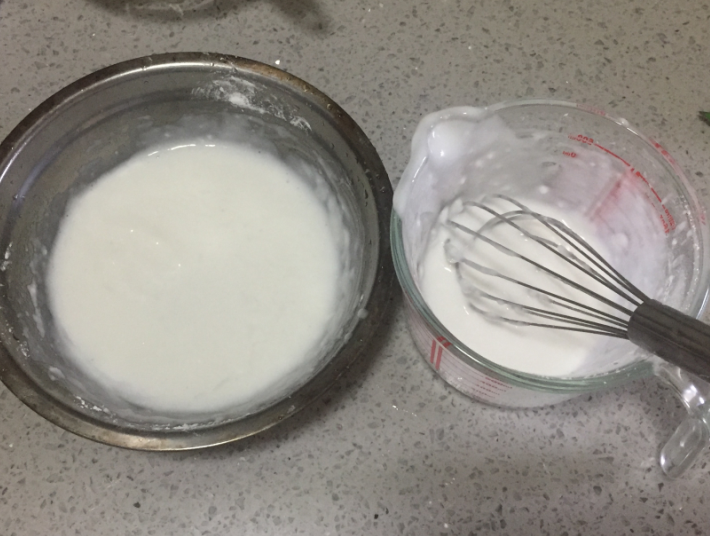 双色水晶糕,首先,我们把100克的水晶粉分成两份,每份50克,然后分别与清水和杏仁露两种液体原料混合,搅拌成均匀的面糊(喜欢吃甜的可以在这一步放糖)。