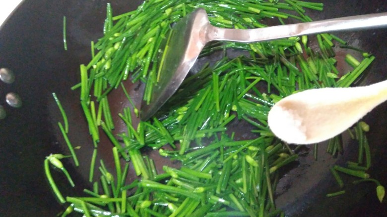 韭苔炒胗花,开火,锅热后放油,倒入韭苔,加少许清水翻炒,加一点点盐。